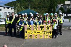 交通安全啓発に参加した大誉地小の児童と拓殖工業の職員ら