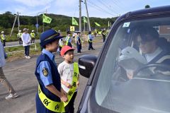 国道２４２号を通行するドライバーに安全運転を呼びかける大誉地小の児童