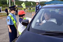 国道２４２号を通行するドライバーに安全運転を呼びかける大誉地小の児童