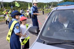 国道２４２号を通行するドライバーに安全運転を呼びかける大誉地小の児童