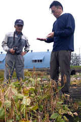 辻野さん（左）から今年産の小豆について説明を受ける森本社長（右）