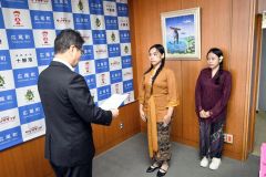 辞令交付を受けるアプリリアさん（中央）とエルナさん（右）