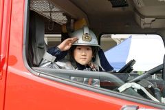 消防車に乗って笑顔で記念撮影をする子ども