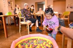 グループホーム内で縁日を楽しむ家族らに目を細める入居者ら
