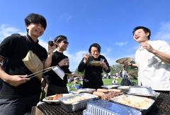 秋晴れの下、ワインを片手に食事を楽しむ来場客（５日午前１０時５０分ごろ、塩原真撮影）
