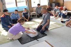 心肺蘇生法などを学ぶサーファー