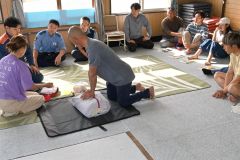 心肺蘇生法などを学ぶサーファー