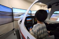 空港大学校の訓練機シミュレーターを操作する子ども（須貝拓也撮影）