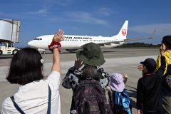羽田空港行きの旅客機へ手を振るお見送り体験の参加者（須貝拓也撮影）
