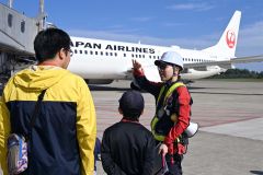 空港スタッフから機体の説明を受けるお見送り体験の参加者（須貝拓也撮影）