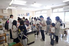 調理室の飲食コーナーで列をつくる来場者たち