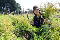 本別産の陸稲を刈り取り、満面の笑みを浮かべる高橋さん