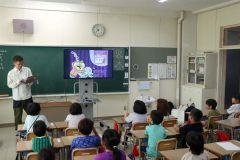タブレットで絵本の読み聞かせを行うおがわさん