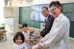 絵本作家のおがわひろきさん（右）から絵本を受け取った１年生