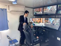 運転シミュレーターで状態を確かめる参加者ら