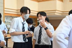 折り紙に書いた自分の良いところを相手に紹介し合う生徒たち