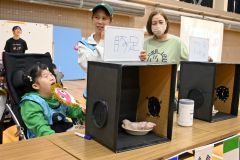 箱の中の物を当てる親子連れ