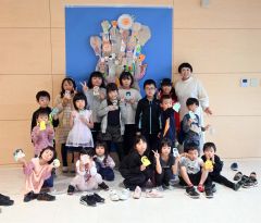 完成した気球の前でポーズを取る子どもたち。右奥は加藤さん