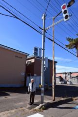 ひびき野東町１の道道に新設された押ボタン式信号機を紹介する宝来地区町内会連合会の竹内会長