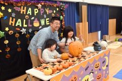 完成したカボチャのランタンと記念撮影する親子