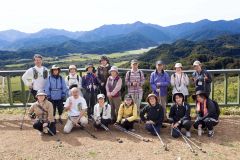 山頂展望台まで歩き、日高山脈の雄大な景色をバックに記念撮影する参加者ら