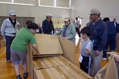 地域住民とダンボールベッドの組み立てに挑戦する児童たち