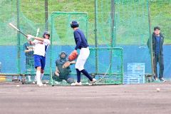 亀田直紀監督（右）が見守る中、打撃練習を行う白樺学園の菊島有佑主将