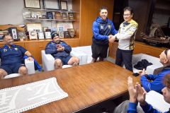 贈られたニウエ代表のジャージを着てシーニー選手と握手するた田中町長
