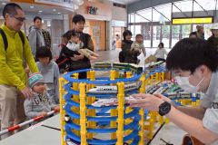 ＪＲ帯広駅構内の東コンコースに設置されたプラレールに見入る家族連れ（１８日午前１０時半ごろ、金野和彦撮影）