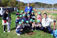 子どもたちと一緒に植樹セレモニーを行った山田支店長（最後列）と田中町長（右）