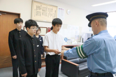 澁谷署長（手前）から表彰状を受け取る大左古会長（中央）