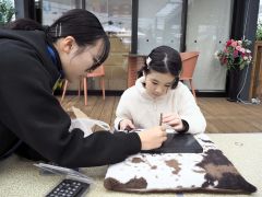 キーホルダー作りを教える生徒