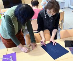 アイヌ文様刺繍講座で参加者にアドバイスをする太田さん（右）