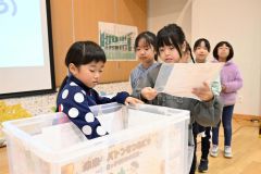 思い出の品をタイムカプセルに入れる児童ら