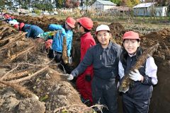 大きなナガイモを折らずに掘り上げて笑顔を見せる児童（２３日午前１０時ごろ、須貝拓也撮影）
