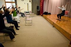 講師の清野さんと「ハッピーチェア・エクセサイズ」に取り組む参加者ら