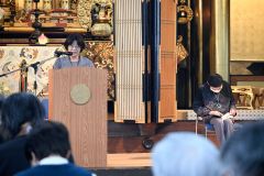 語り部の浅見さん（左）と資料に目を通す吉澤さん