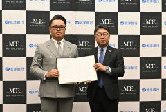 協定書を手にする（左から）水戸社長と津山頭取
