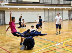 寝そべった状態から素早く立ち上がるトレーニングを指導する佐藤さん（右）