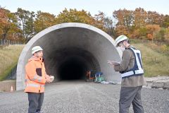 貫通した広内トンネルについて説明する山形所長（左）