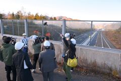 供用開始に向け工事が進む現場を報道陣に説明する對馬工事長（奥）