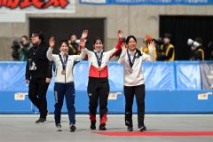 女子3000メートルの表彰を終え、観客に向かって手を振る堀川桃香(中央)。右は2位の高木美帆、左は3位の佐藤綾乃(金野和彦撮影)