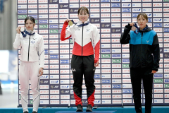女子5000メートル表彰で金メダルを掲げ、笑顔で記念写真に収まる堀川桃香(中央)。右は3位の飯田明音、左は2位の高橋侑花(金野和彦撮影)