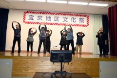 出演者のカラオケをＢＧＭにステージ上で創作体操を披露する住民