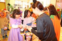 「トリックオアトリート！」と声を掛けて園内を回り教諭からお菓子をもら
う園児たち