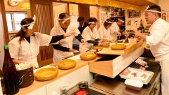 池田社長(写真右)から、すしのにぎり方を学ぶ体験ツアー参加者