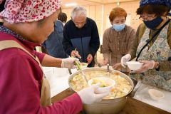 取れたての新鮮野菜を使った豚汁を器によそう地域住民ら