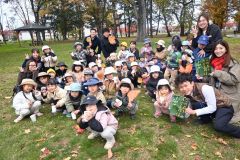 宝探し終了後、写真絵本などを抱え記念撮影する園児ら