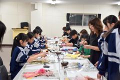 松浦さん（写真右から２人目）から「しめ縄アレンジ」の作り方を学ぶ中学生