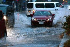 落ち葉の影響で冠水した道路を進む自動車(1日午前8時40分ごろ、西1南12で。塩原真撮影)